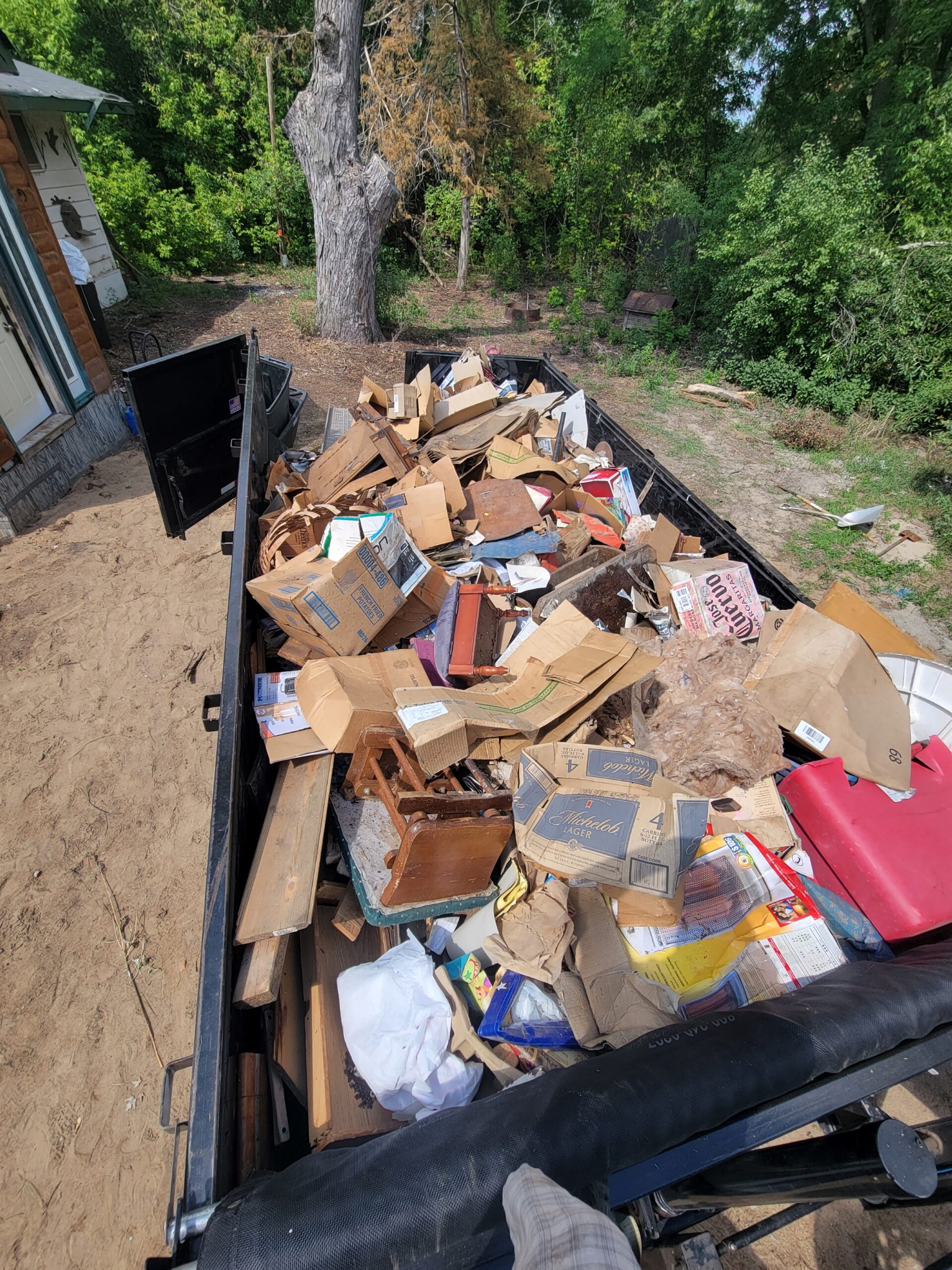 A trailer filled with trash and debris. Foreclosure clean out services offered.